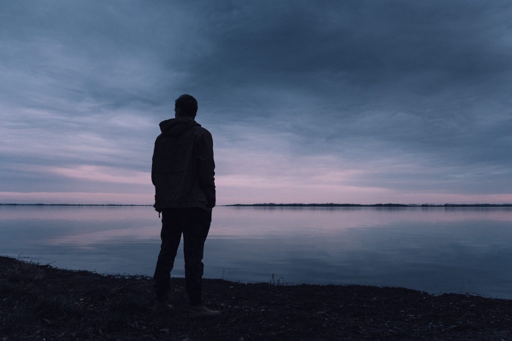 Kuva: mies seisoo järven rannalla